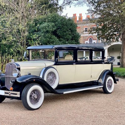 Cream and black Bramwith vintage wedding car on a country estate driveway
