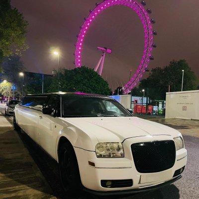White stretch Chrysler 300 limousine by the London Eye at night