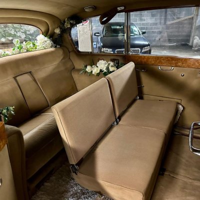 Vintage wedding car interior with tan upholstery and floral trim